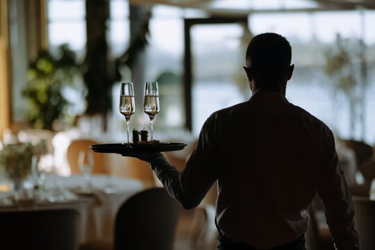 Waiter Carrying Drinks in a Stylish Restaurant Setting
