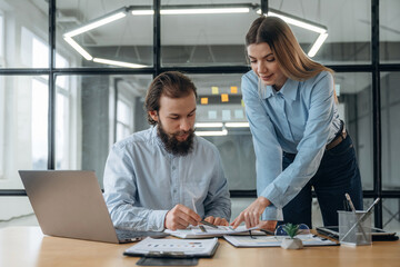 Talking, working with documents. Man and woman are in the office together