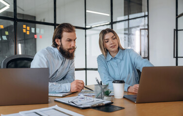 Successful, smiling and working. Man and woman are in the office together