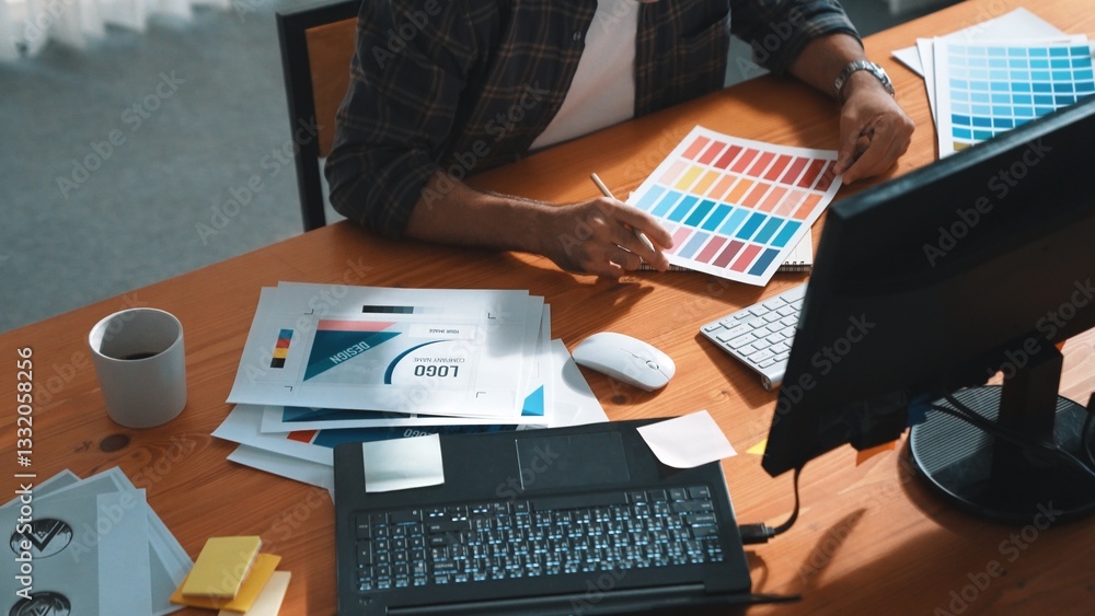 Poster close up of smart business man hand choosing color palettes while sitting at meeting table with note