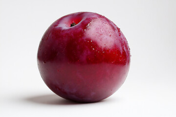 Obraz premium a realistic photograph of a ripe plum against a white background,