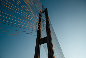 Suspension bridge tower at sunset. Looking up at the concrete pylons of cable-stayed bridge.