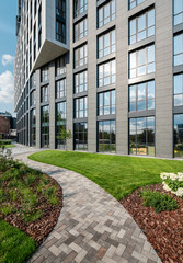 Path in a garden near modern office building. Green area in downtown district - curvy footpath...