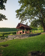 Wooden gazebo on the hill. Small pavilion in a park at sunset.