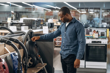 Vacuum cleaners. Man in a home appliance store
