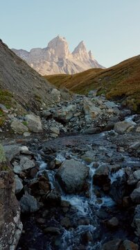 Landscape of Aiguilles d Arves of rugged rocky mountain peak and cascade flowing during autumn in Maurienne Valley at France