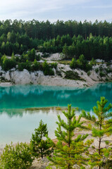 Summer landscape scene - forest trees and turquoise waters of kaolin quarry locally named Bali,...