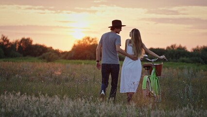A Lovely Couple Enjoying a Beautiful Sunset While Riding Their Bicycle in a Serene Field