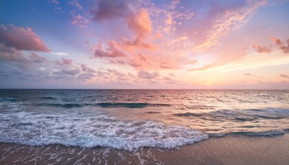 Fototapeta premium Breathtaking pastel-colored sunset over the tranquil ocean, with soft gentle waves lapping the shore and fluffy clouds drifting across the colorful sky