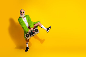 Eccentric mature man dancing with boombox and vibrant outfit