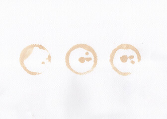 Watercolor blots from coffee on white drawing paper background.