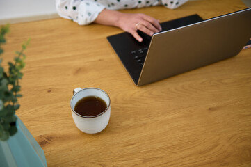 Cozy Remote Work Setup With Laptop and Tea on Wooden Desk