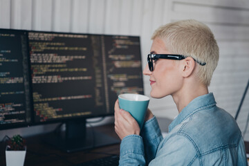 Confident Programmer Enjoying a Coffee Break While Working in Her Home Office on Coding Projects