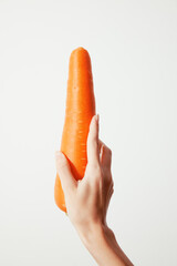 Person holding a carrot on a white background with white space in the middle