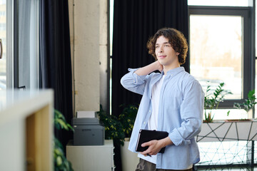 Fototapeta premium Young handsome man in office reflecting on successful career ambitions and personal growth journey