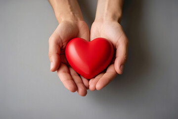 Obraz premium Hand Holds a Red Heart-Shaped Gift