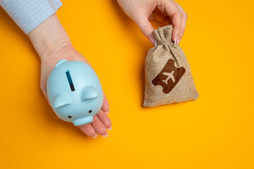 Piggy bank and a bag of airline tickets. The concept of saving on flights, accumulating bonuses and...