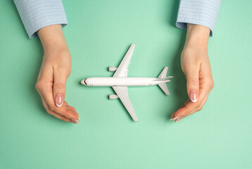 Hands in a gesture of protection of a passenger plane. Protection of the air transport industry....