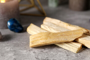 Palo santo sticks and gemstones on grey table, closeup