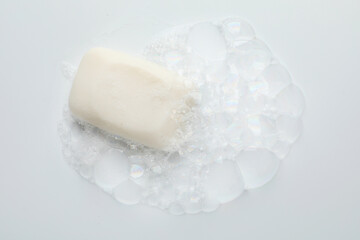 Soap bar with foam on white background, top view