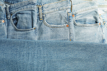 Many stylish jeans as background, top view