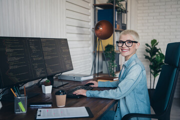 Young professional woman coding on a computer in a stylish home office