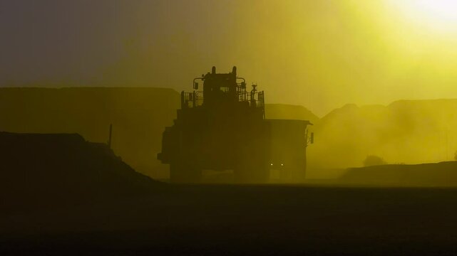 massive mining truck illuminated by sunset, at dusty site open pit diamond mine and construction , capturing the beauty of industrial environment