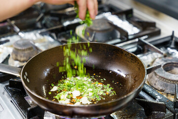 Fresh Herbs Added to Sizzling Pan