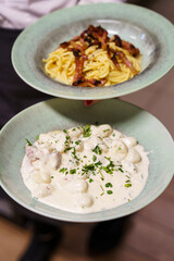 Spaghetti Carbonara and Creamy Gnocchi in Green Bowls