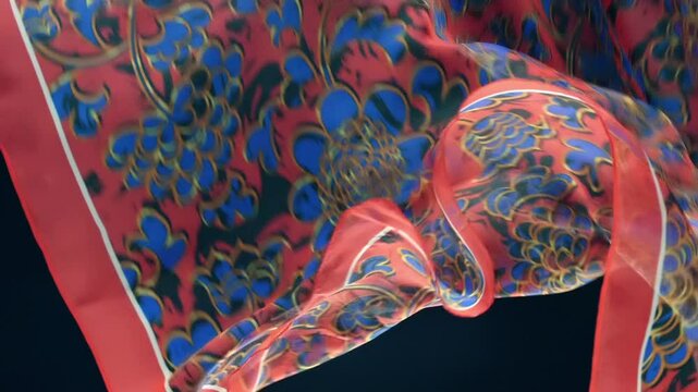 Red fabric with beautiful blue floral pattern falls, fluttering on a black background. Closeup. Macro. Slow mo, slow motion, high speed camera, 200fps