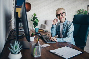 Young professional woman in casual style working from a modern home office wearing a denim shirt...