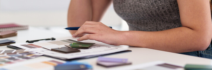 Creative Vision: A person's hands meticulously arranging fabric swatches on a work table,...