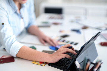 Creative Workspace: A person is at work on a table scattered with tools of their trade.