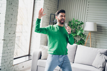 Man singing enthusiastically in a well-lit living room while enjoying his free time during a sunny...