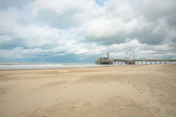 The Ferris Wheel and the pier in Scheveningen, the Hague, Netherlands. Cloudy day at the beach of North Sea.