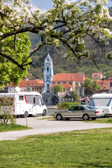 Dürnstein village with church against camping area next to the Danube river during spring time in Wachau, Austria