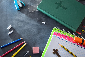 Educational background with school supplies on a blackboard with Bible