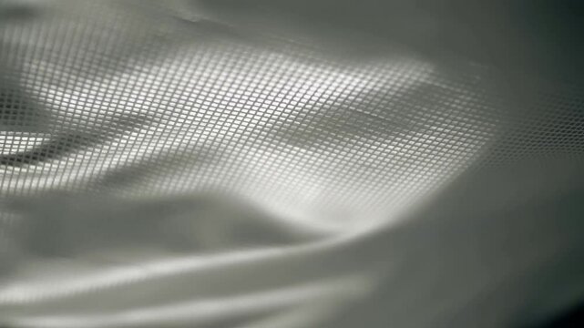 Fabric with a shiny checkered pattern flutters in the wind. Closeup. Macro. Slow mo, slow motion, high speed camera, 200fps
