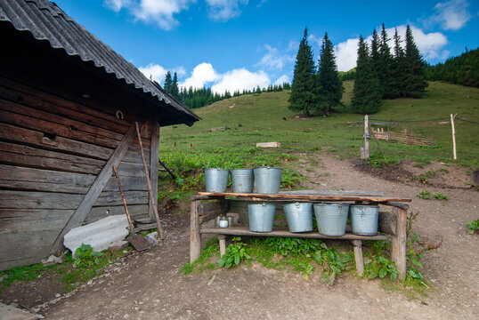 Milk buckets and cheesemaker house in Carpathian mountains