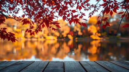 An autumn scene with vibrant orange and red leaves on tree branches framing a calm lake, a rustic wooden deck or table in the foreground, and blurred autumn foliage reflecting in the water