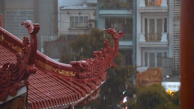 Beautiful roof of a Buddhist temple in Vietnam, with its edges folded up, during heavy tropical rain. Slow mo, slow motion, high speed camera, 200fps