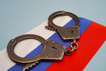 The handcuffs are placed on the national flag of the Russian Federation.
