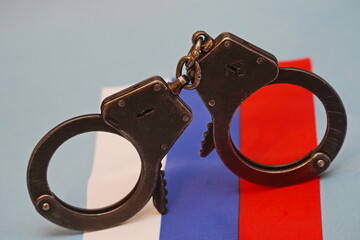 The handcuffs are placed on the national flag of the Russian Federation.