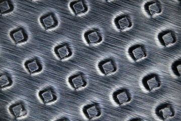 Une feuille d'aluminium alvéolée en microscopie au dos d'une plaquette de médicament