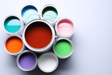 Cans of bright paints on light background, above view. Space for text