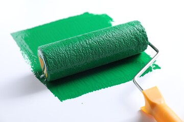 Smear of green paint and roller on white background, closeup