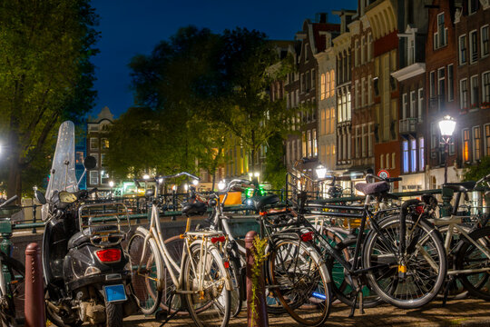 Parked Mopeds and Bicycles in Amsterdam at Night