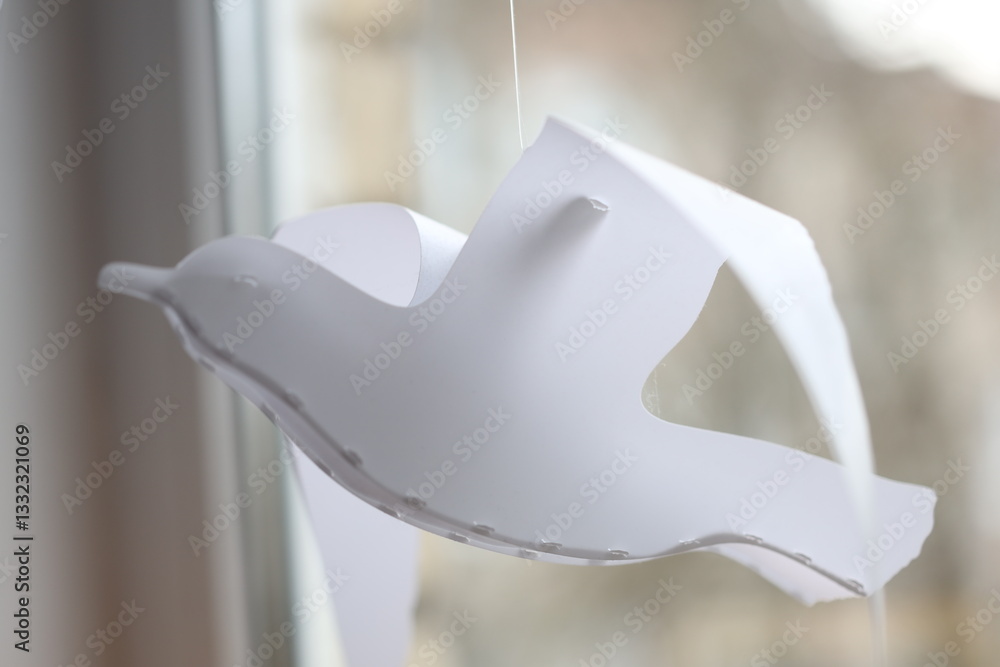 Poster A small bird hangs from a window sill.