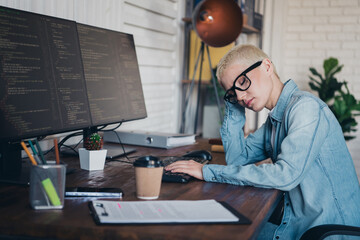 Young programmer working on code at her computer station in a home office environment