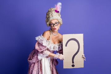 Elegant woman in royal costume holding cardboard with question mark against vibrant purple background
